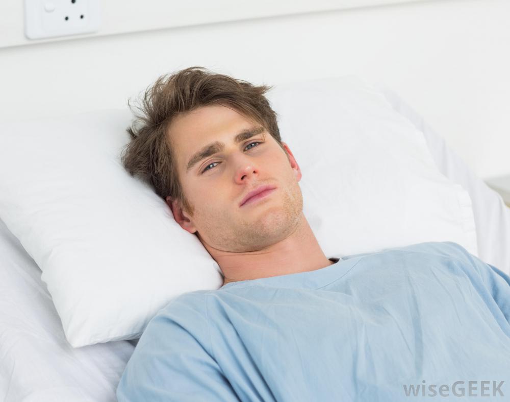 man-in-blue-hospital-gown-against-pillow.jpg